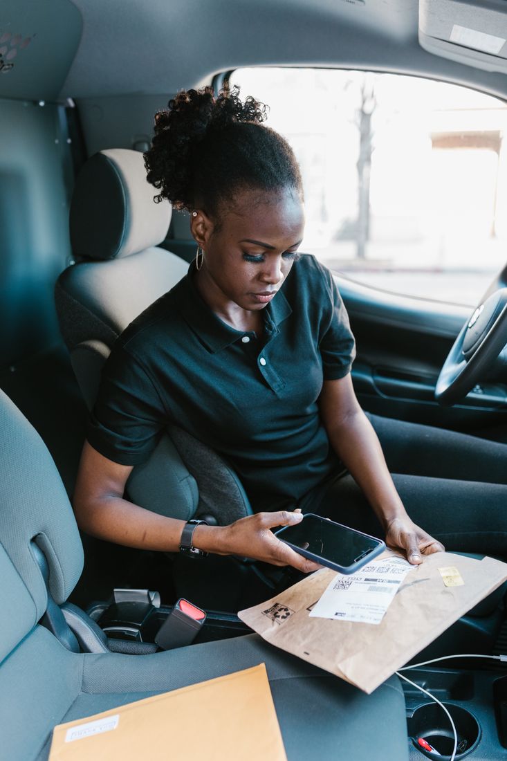Courier scanning a parcel barcode in a delivery van