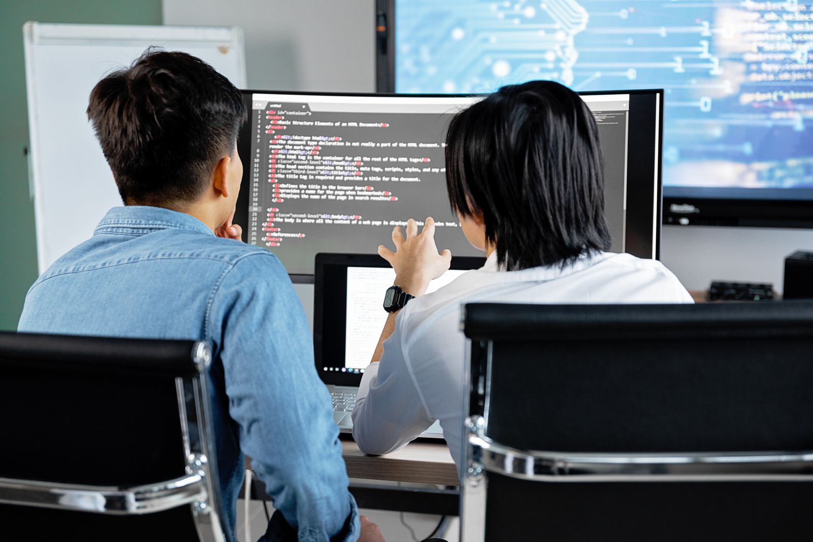 Two SID engineers discussing code on a screen at the Ho Chi Minh City studio